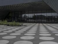 the floor of a building with a circular pattern on it in front of an angled glass building