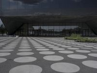 the floor of a building with a circular pattern on it in front of an angled glass building