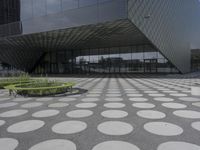 the floor of a building with a circular pattern on it in front of an angled glass building