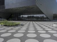 the floor of a building with a circular pattern on it in front of an angled glass building