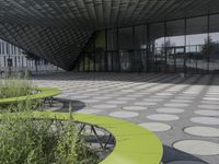 the floor of a building with a circular pattern on it in front of an angled glass building