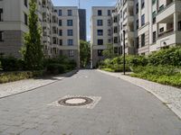 a brick road with white steppings leading to white apartment buildings that appear similar, but different styles of apartments