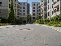 a brick road with white steppings leading to white apartment buildings that appear similar, but different styles of apartments