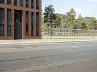 a stop light near an empty street and a fenced off area in front of buildings