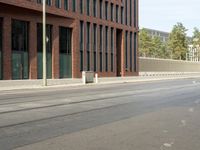 a stop light near an empty street and a fenced off area in front of buildings