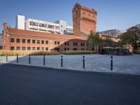 a brick building and sidewalk in an empty space between two buildings with a building in the background