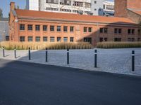 a brick building and sidewalk in an empty space between two buildings with a building in the background