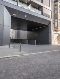 a black concrete structure and a white brick sidewalk with two steps leading to the entrance