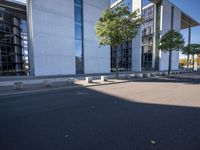 a parking lot with a sidewalk and large windows on a sunny day in the sun