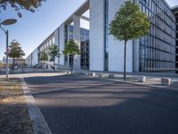 a parking lot with a sidewalk and large windows on a sunny day in the sun