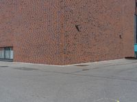 an empty parking lot with a fire hydrant near it on a city street in front of a brick building