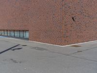 an empty parking lot with a fire hydrant near it on a city street in front of a brick building