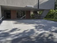 a view of a sidewalk with a building behind it that has a door way in front