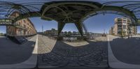 this is a fish - eye view of the park area from beneath a bridge that spans over water