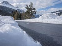 there is a mountain with a lot of snow and a snow shovel next to the road