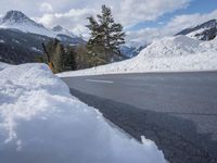 there is a mountain with a lot of snow and a snow shovel next to the road