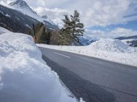 there is a mountain with a lot of snow and a snow shovel next to the road