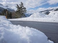 there is a mountain with a lot of snow and a snow shovel next to the road