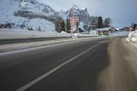 a speed moving view of a snowy road and snow covered mountains from inside the car