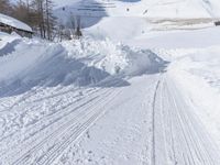 a cabin is surrounded by many piles of snow on the ground in front of a ski slope