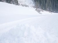 a skier is riding across the snow in the mountains side country road and near a house