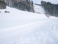 a skier is riding across the snow in the mountains side country road and near a house