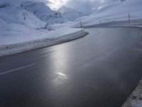 a motorcycle is going down a snowy road, and it looks very steep ahead in the picture