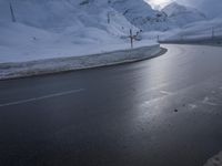 a motorcycle is going down a snowy road, and it looks very steep ahead in the picture