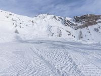 the skier is headed up a hill to the top of the mountain with skis on their feet