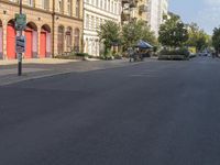 an empty street with buildings in the background and street lamps on each side, and red garage doors open