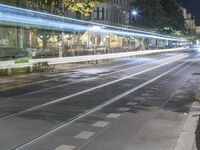 long exposure of the city at night, showing street lights in motion, and people on bicycles passing