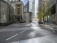 an empty city street in front of modern buildings in the city of london, uk