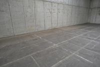 a parking spot is seen on the ground and empty wall of an unfinished parking garage