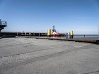 a boat sitting in the port with a dock in the background a clear blue sky