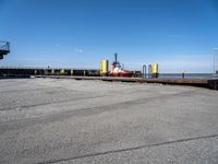 a boat sitting in the port with a dock in the background a clear blue sky