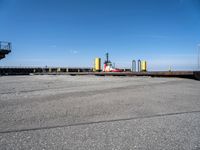 a boat sitting in the port with a dock in the background a clear blue sky