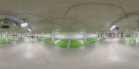 an empty parking garage with many people walking down the hallway and stairs with green and white paint