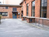 a bike parking space near some red brick buildings and stairs with benches on both sides of the walkway