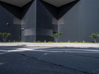 a black building with black squares on the top and bottom, along with a stop light and no parking