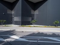 a black building with black squares on the top and bottom, along with a stop light and no parking