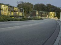 a car drives along the road near an office complex at night in front of a building