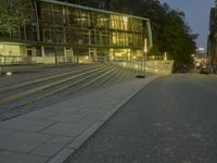 a car drives along the road near an office complex at night in front of a building