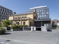 a large building with a parking lot in front of it and some buildings behind it