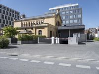 a large building with a parking lot in front of it and some buildings behind it