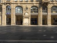 a building with multiple windows is shown in the picture of the street corner has an open area that has a no parking sign on it and signs in the doorways