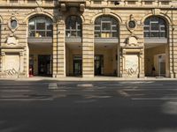 a building with multiple windows is shown in the picture of the street corner has an open area that has a no parking sign on it and signs in the doorways