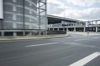 a highway with two lanes and large buildings behind it and people walking next to the road