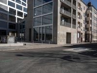 an empty city street with an intersection sign and graffiti on the side of the building