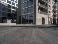 an empty city street with an intersection sign and graffiti on the side of the building