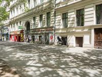 a restaurant in the middle of a narrow city street with graffiti on the wall and the sidewalk outside the building